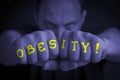 OBESITY written on an angry manÃ¢â¬â¢s fists